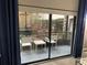 View of a screened patio area with two white chairs and a small table outside a sliding glass door at 14501 Grove Resort Ave # 3406, Winter Garden, FL 34787