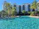 Beautiful resort-style pool with lounge chairs surrounded by lush tropical landscaping near the condos at 14501 Grove Resort Ave # 3406, Winter Garden, FL 34787