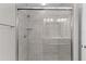 A new walk-in shower with grey tile and a glass door at 14611 Se 95Th Ct, Summerfield, FL 34491