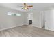 A bedroom with hardwood floors, ceiling fan, and an ensuite bathroom with a black vanity cabinet at 14611 Se 95Th Ct, Summerfield, FL 34491