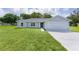 Inviting single-story home with a well-manicured lawn and an attached two-car garage at 14611 Se 95Th Ct, Summerfield, FL 34491