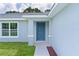Close-up of a home's front entrance, showcasing a stylish blue door and trim at 14611 Se 95Th Ct, Summerfield, FL 34491