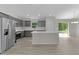 Spacious kitchen with stainless steel fridge, gray cabinets, and an island at 14611 Se 95Th Ct, Summerfield, FL 34491
