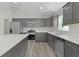 Modern kitchen with stainless steel appliances, quartz countertops, and gray cabinets at 14611 Se 95Th Ct, Summerfield, FL 34491
