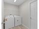 Bright laundry room with modern washer and dryer, wire shelving, and neutral paint at 14611 Se 95Th Ct, Summerfield, FL 34491