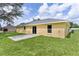 Rear exterior of the house showing a patio and lush green yard, perfect for outdoor enjoyment and relaxation at 14631 Se 95Th Ct, Summerfield, FL 34491