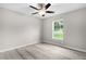 Bright bedroom featuring updated floors, a ceiling fan, and a window with a backyard view at 14631 Se 95Th Ct, Summerfield, FL 34491