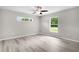 Light-filled bedroom featuring wood floors, ceiling fan, and multiple windows for plenty of natural light at 14631 Se 95Th Ct, Summerfield, FL 34491