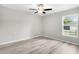 Bedroom features updated floors, a ceiling fan, and a window with a yard view at 14631 Se 95Th Ct, Summerfield, FL 34491
