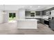 Modern kitchen with stainless steel appliances, white countertops, an island, and a slider to the exterior at 14631 Se 95Th Ct, Summerfield, FL 34491