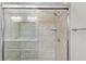 Walk-in shower with grey tile and glass door at 14631 Se 95Th Ct, Summerfield, FL 34491