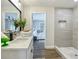 Bathroom featuring a walk-in shower, sleek vanity, and stylish decor, with a peek into the main bedroom at 1611 Canal, Tavares, FL 32778