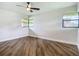 Bright bedroom with hardwood floors, a ceiling fan, and two windows at 1611 Canal, Tavares, FL 32778