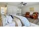 Spacious main bedroom showcasing hard wood floors, a ceiling fan, two leather chairs, and ample closet space at 1611 Canal, Tavares, FL 32778