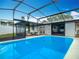 Sparkling pool surrounded by a screened enclosure and outdoor seating, perfect for relaxation and entertaining at 1611 Canal, Tavares, FL 32778