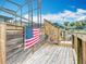 Wooden deck with an American flag adjoins the screened enclosure covering an inviting pool area at 1611 Canal, Tavares, FL 32778