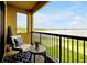 Relax on the spacious balcony with beautiful lake views, furnished with comfortable seating and a small table at 16300 County Road 455 # 202, Montverde, FL 34756