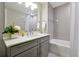 Stylish bathroom with gray vanity, a framed mirror, and a bathtub with elegant subway tile surround at 16300 County Road 455 # 202, Montverde, FL 34756