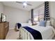 Bedroom with two twin beds, ceiling fan, and window with patterned curtains, filled with natural light at 16300 County Road 455 # 202, Montverde, FL 34756