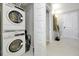 Convenient laundry room with stacked washer and dryer units near a hallway, maximizing space and efficiency at 16300 County Road 455 # 202, Montverde, FL 34756