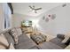 Inviting living room with a gray sectional sofa, patterned ottoman, modern lighting, and entertainment center at 16300 County Road 455 # 202, Montverde, FL 34756