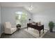 Staged bedroom with vaulted ceilings, a ceiling fan, gray wood-look floors, and a large arched window at 16862 Se 80Th Bellavista Cir, The Villages, FL 32162