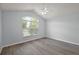 Bright bedroom with vaulted ceilings, a ceiling fan, and gray wood-look floors, plus a large arched window at 16862 Se 80Th Bellavista Cir, The Villages, FL 32162