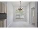 Cozy dining area featuring a chandelier, large window, and modern tile flooring at 16862 Se 80Th Bellavista Cir, The Villages, FL 32162