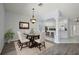 Dining room with decorative chandelier, dining table and chairs, with open view to the kitchen at 16862 Se 80Th Bellavista Cir, The Villages, FL 32162