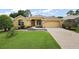 Charming single-story home with a well-manicured lawn and a paved driveway leading to a two-car garage at 16862 Se 80Th Bellavista Cir, The Villages, FL 32162