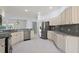Well-lit kitchen featuring white cabinetry, granite countertops, stainless steel appliances, and tile flooring at 16862 Se 80Th Bellavista Cir, The Villages, FL 32162
