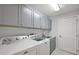 This laundry room features ample cabinet space, a sink, and newer appliances at 16862 Se 80Th Bellavista Cir, The Villages, FL 32162