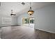 Living area with gray floors, vaulted ceiling, fan and access to the screened pool and patio at 16862 Se 80Th Bellavista Cir, The Villages, FL 32162