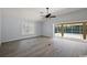 Bright living room features gray flooring, a ceiling fan, and sliding glass doors to the pool at 16862 Se 80Th Bellavista Cir, The Villages, FL 32162