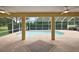 Screened-in pool area with covered patio featuring ceiling fans, stone floors and view of the yard at 16862 Se 80Th Bellavista Cir, The Villages, FL 32162