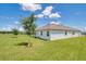 Expansive backyard, features lush green grass, young trees, and a pristine exterior with crisp white trim at 1696 Wilson Prairie Cir, Groveland, FL 34736