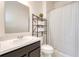 Well-lit bathroom with a modern vanity, framed mirror, and a shower-tub combination with a white shower curtain at 1696 Wilson Prairie Cir, Groveland, FL 34736