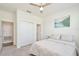 Cozy bedroom featuring soft carpet, a lake print wall art, a ceiling fan, and natural light from a large window at 1696 Wilson Prairie Cir, Groveland, FL 34736