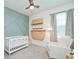 Cozy Bedroom featuring a crib, comfortable armchair, and stylish wall decorations at 1696 Wilson Prairie Cir, Groveland, FL 34736