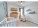 Inviting Bedroom with crib, bookshelf, and comfortable chair, perfect for a growing Gathering at 1696 Wilson Prairie Cir, Groveland, FL 34736
