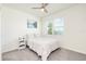 Comfortable bedroom featuring a neutral color palette, soft carpet, ceiling fan and natural light from a large window at 1696 Wilson Prairie Cir, Groveland, FL 34736