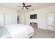 Carpeted bedroom with ceiling fan, TV, and view to the ensuite bathroom at 1696 Wilson Prairie Cir, Groveland, FL 34736