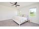 Bright bedroom featuring a ceiling fan, plush carpeting, and natural light from dual windows at 1696 Wilson Prairie Cir, Groveland, FL 34736
