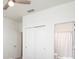 Bright bedroom with carpet floors, a ceiling fan, closet and a bathroom featuring a white shower curtain at 1696 Wilson Prairie Cir, Groveland, FL 34736