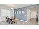 Bright dining room featuring a modern chandelier, wood table, and gray accent wall with stylish artwork at 1696 Wilson Prairie Cir, Groveland, FL 34736