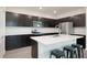 Bright kitchen featuring dark cabinets, stainless steel appliances, quartz countertops, an island, and a modern sink at 1696 Wilson Prairie Cir, Groveland, FL 34736