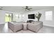 Bright living room featuring a ceiling fan, a gray sectional sofa, and a large window with natural light at 1696 Wilson Prairie Cir, Groveland, FL 34736