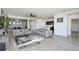Bright open-concept living space with a modern kitchen, dining area, and comfortable gray sectional sofa at 1696 Wilson Prairie Cir, Groveland, FL 34736