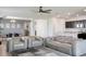 Bright open-concept living space with a modern kitchen, dining area, and comfortable gray sectional sofa at 1696 Wilson Prairie Cir, Groveland, FL 34736