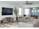 Bright open-concept living space featuring a modern kitchen, dining area, comfortable gray sectional sofa, and TV at 1696 Wilson Prairie Cir, Groveland, FL 34736